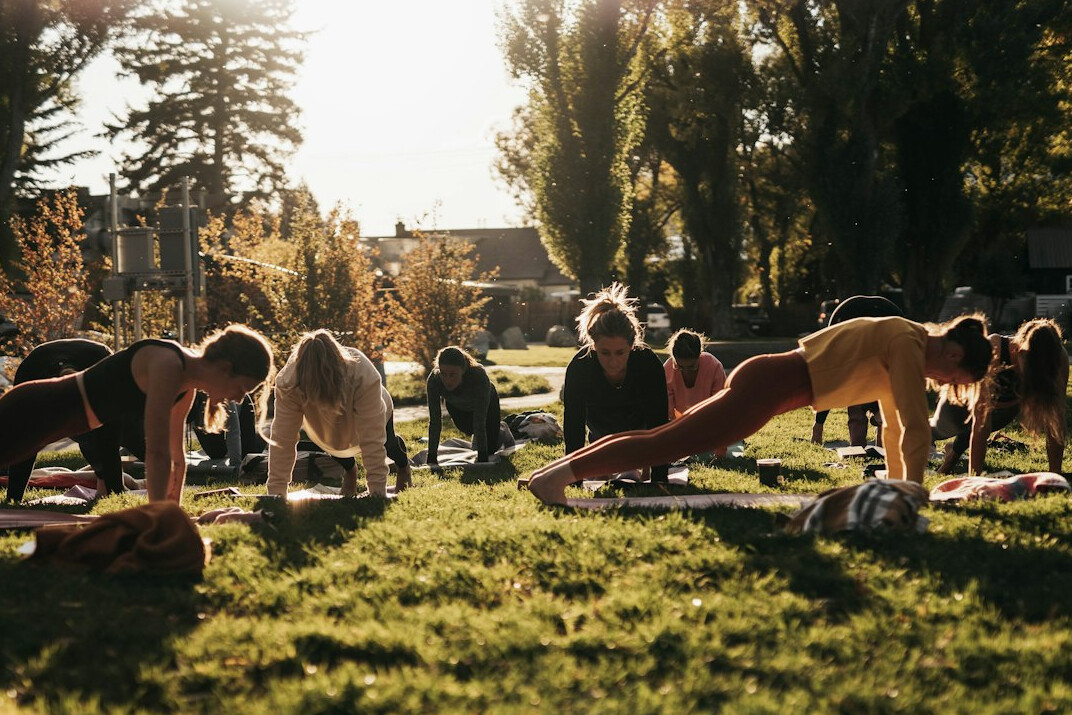Group of diverse people stretching outdoors during a morning wellness session
